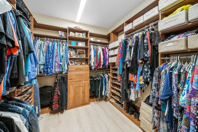 a view of walk in closet with clothes and shoes