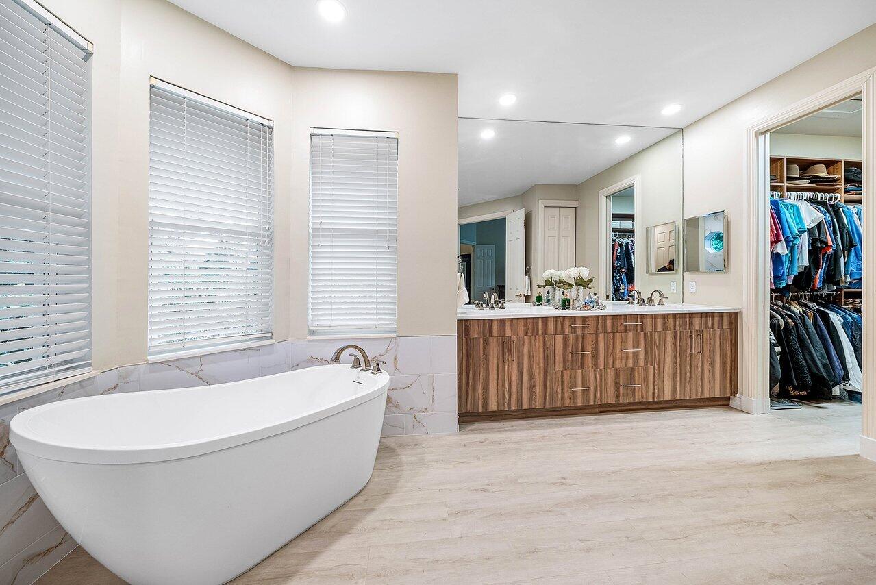 2560 Whispering Oaks Lane Delray Beach, FL 33445 - Photo 25 of 41 a bathroom with a tub sink and a window