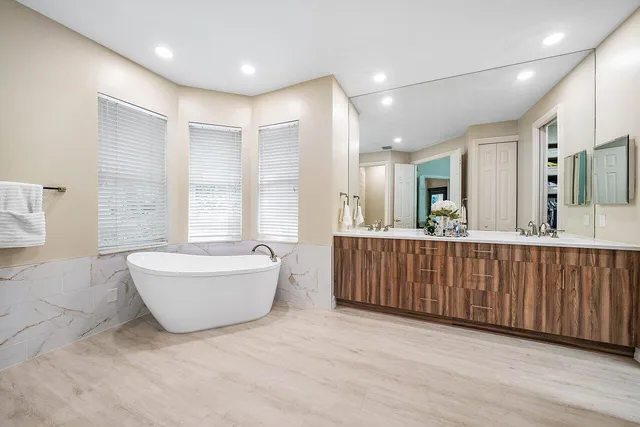 a bathroom with a granite countertop sink mirror and bathtub