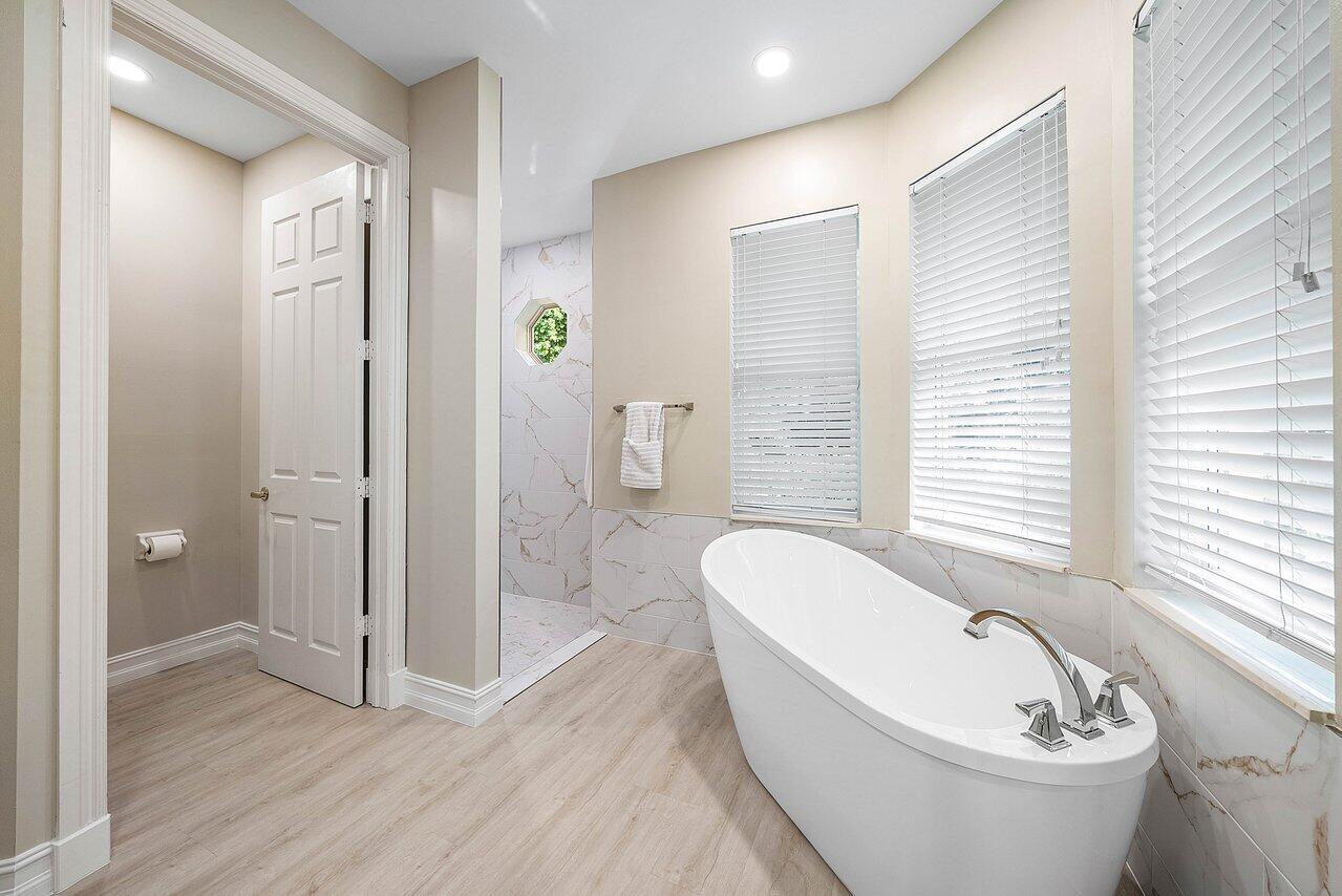 2560 Whispering Oaks Lane Delray Beach, FL 33445 - Photo 27 of 41 a spacious bathroom with a bathtub shower and toilet