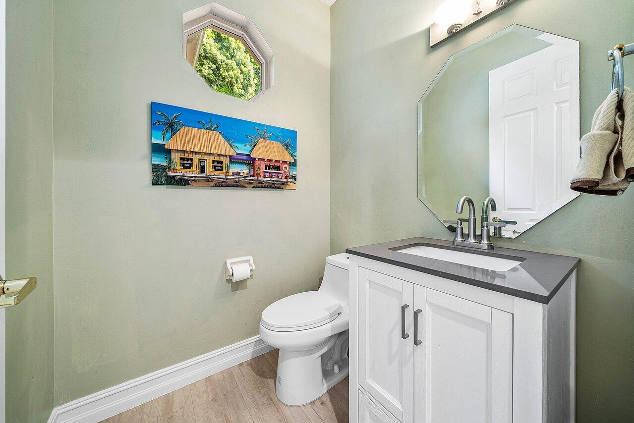 2560 Whispering Oaks Lane Delray Beach, FL 33445 - Photo 33 of 41 a bathroom with a toilet a sink and mirror