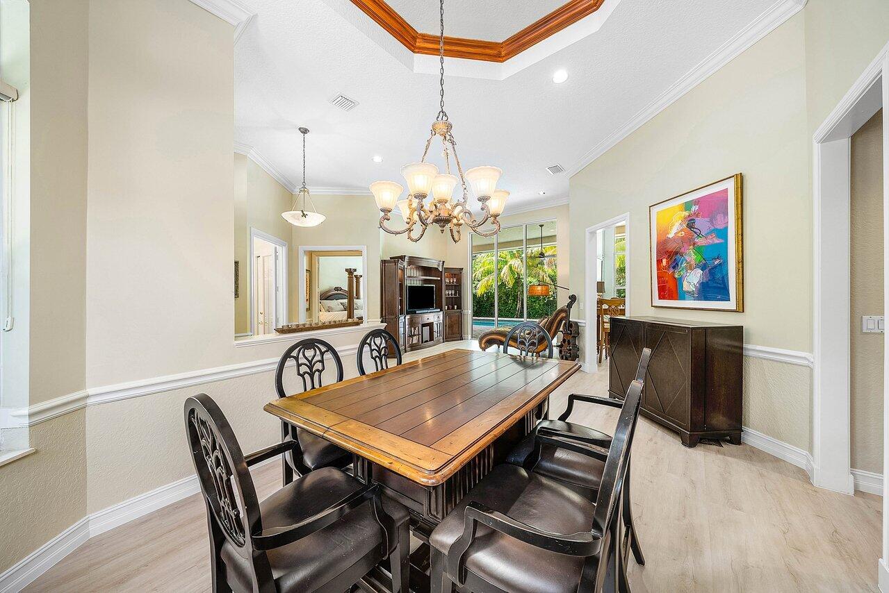 2560 Whispering Oaks Lane Delray Beach, FL 33445 - Photo 8 of 41 a view of a dining room with furniture a chandelier and wooden floor