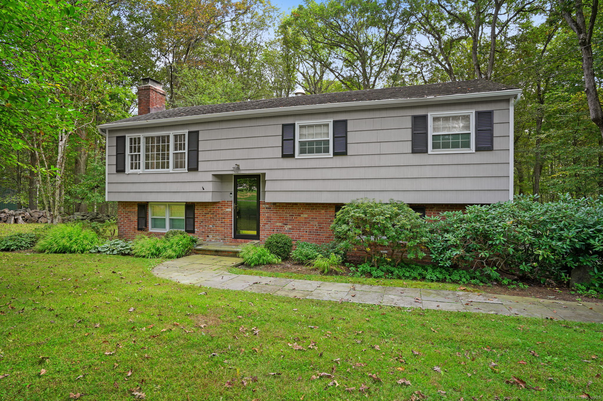 a front view of a house with a yard and trees