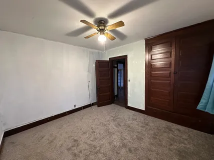an empty room with closet and fan