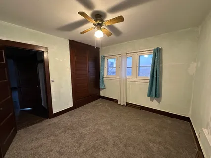 an empty room with closet and windows