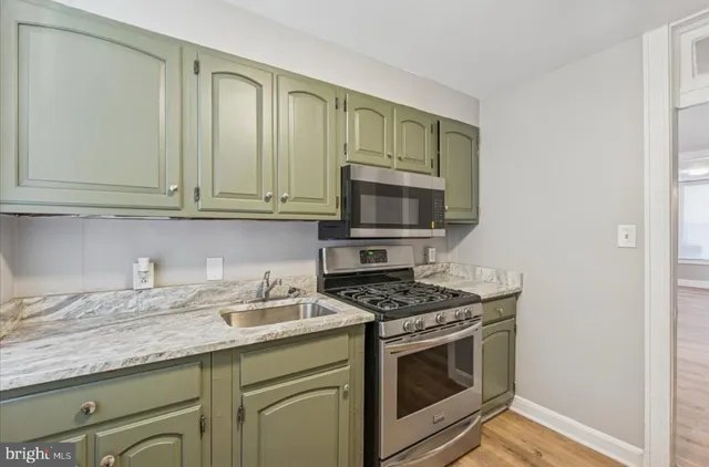 a kitchen with granite countertop a stove top oven microwave and cabinets