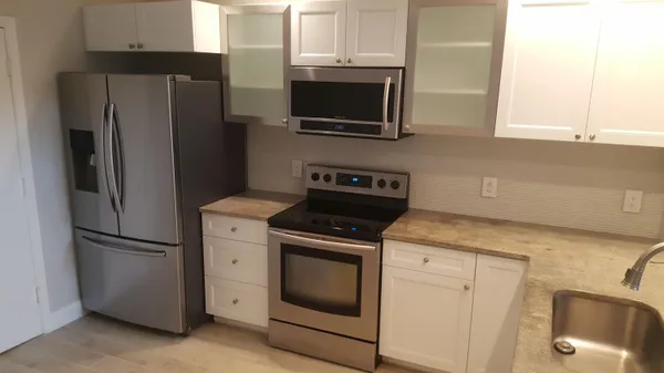 a kitchen with stainless steel appliances white cabinets and a refrigerator