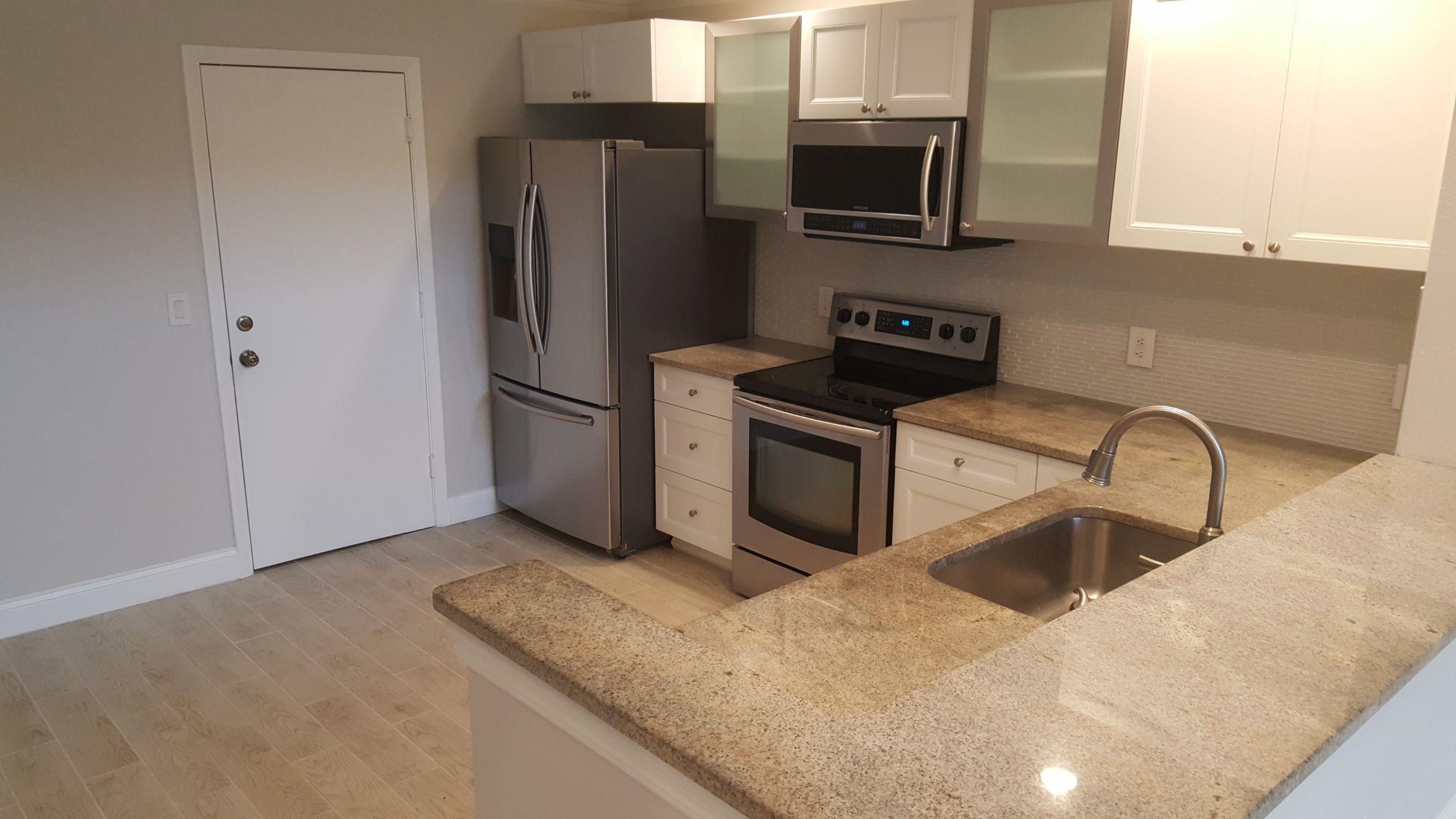 17046 Boca Club Boulevard, Unit 6 Boca Raton, FL 33487 - Photo 4 of 16 a kitchen with stainless steel appliances granite countertop a refrigerator and a sink