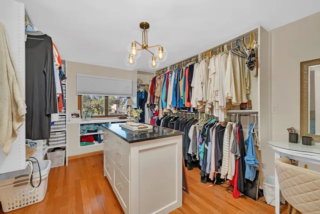 a view of walk in closet with clothes and shoes