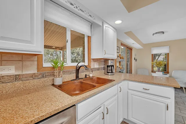 a kitchen with sink a window and cabinets