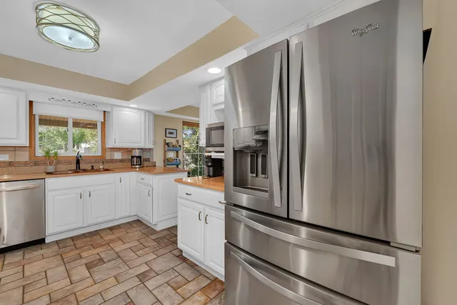a kitchen with stainless steel appliances granite countertop a refrigerator and a sink