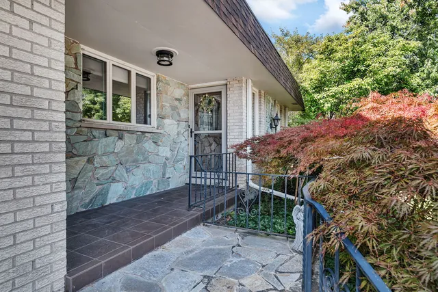 a view of house with wooden stairs and potted plants