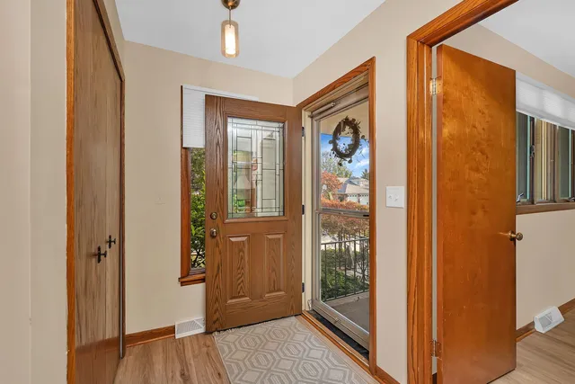 a view of a hallway with wooden floor and a bathroom