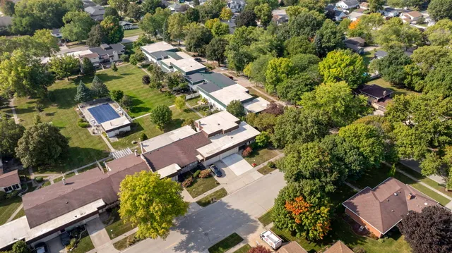 an aerial view of residential house with outdoor space and trees all around