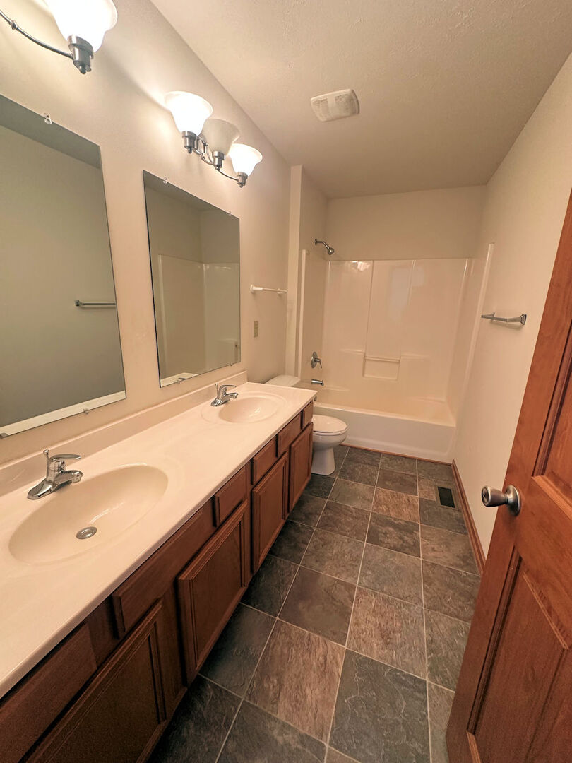 519 South Regulators Street Rochelle, IL 61068 - Photo 17 of 19 a spacious bathroom with a double vanity sink a mirror and a bathtub