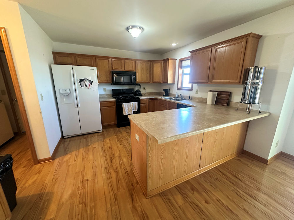 519 South Regulators Street Rochelle, IL 61068 - Photo 2 of 19 a large kitchen with stainless steel appliances a large counter top a sink a refrigerator a stove a microwave and cabinets