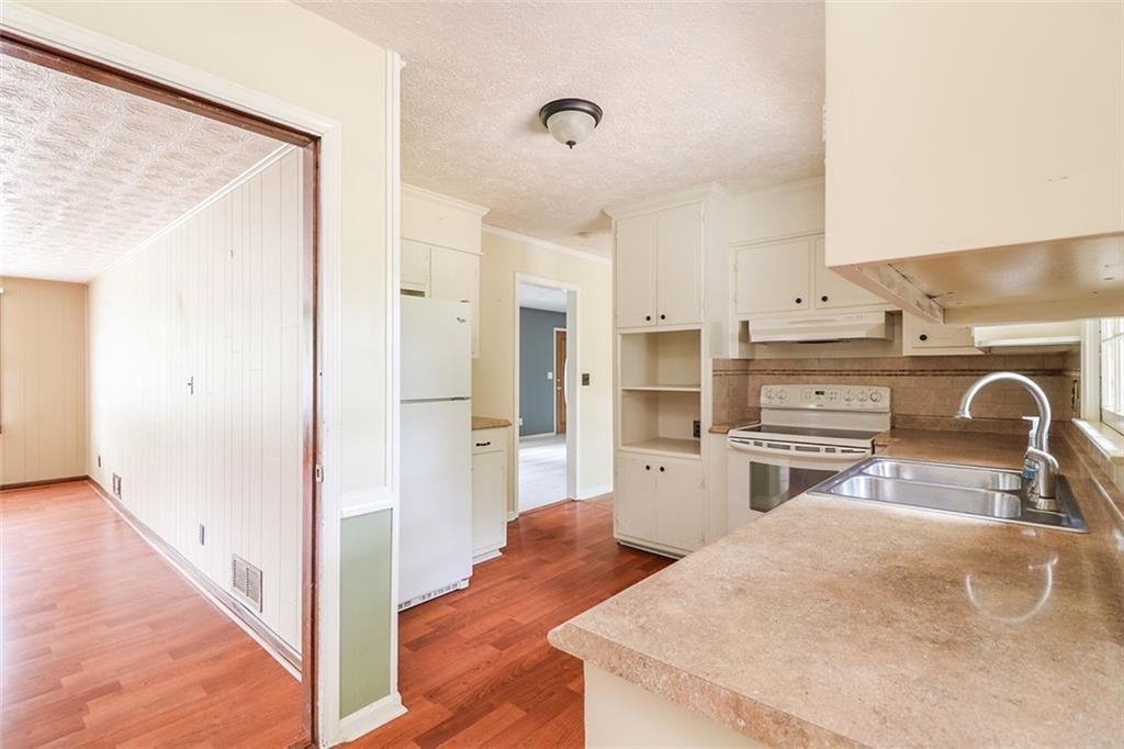 1291 Stephens Street Southwest Lilburn, GA 30047 - Photo 16 of 22 a kitchen with stainless steel appliances kitchen island granite countertop a refrigerator and a sink