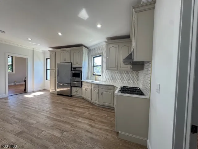 a kitchen with a refrigerator and a stove top oven