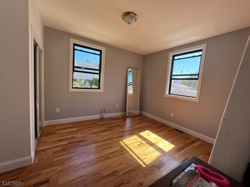 68 Augusta Street, Unit 1 Irvington, NJ 07111 - Photo 4 of 5 a view of an empty room with window and wooden floor