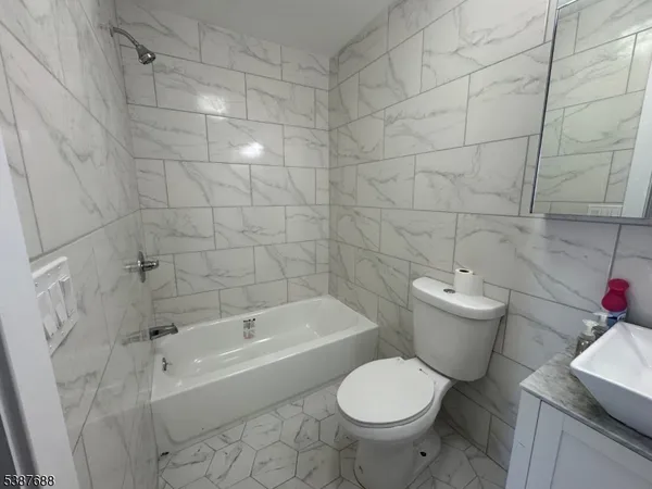 a white toilet and tub sitting next to a bathroom sink