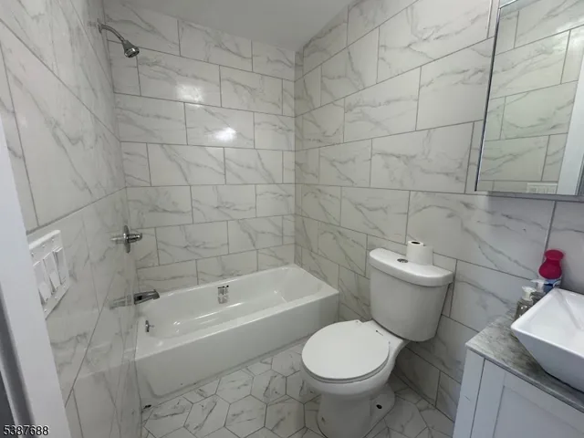 a white toilet and tub sitting next to a bathroom sink