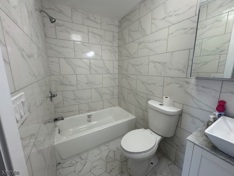 68 Augusta Street, Unit 1 Irvington, NJ 07111 - Photo 5 of 5 a white toilet and tub sitting next to a bathroom sink