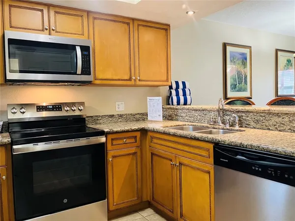a kitchen with granite countertop a sink stove and microwave