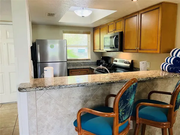a kitchen with stainless steel appliances granite countertop a sink refrigerator and microwave