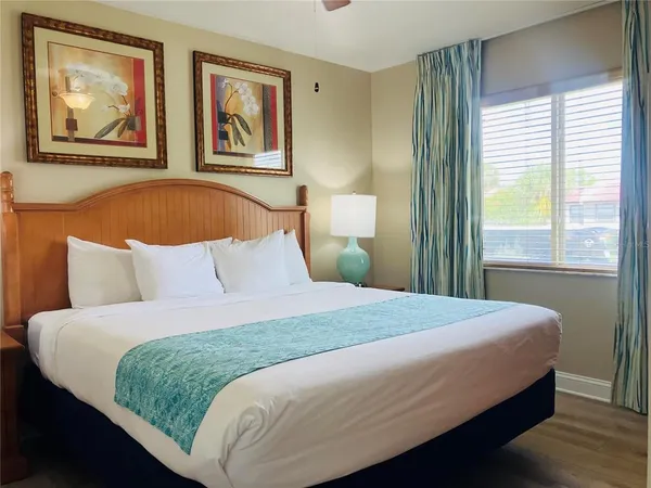 a bedroom with a bed and painting on the wall
