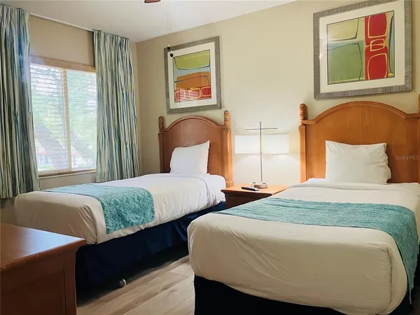 a bedroom with two beds and a window