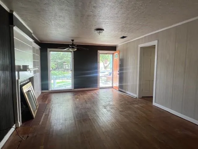 an empty room with wooden floor and a window