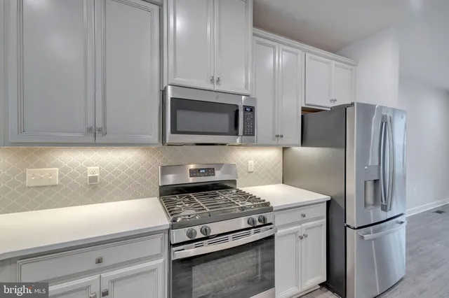 a kitchen with appliances a refrigerator and cabinets