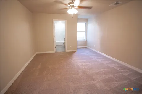 an empty room with windows and fan