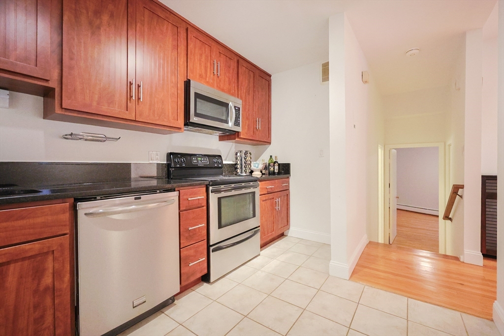 69 East Berkeley Street, Unit 1 Boston, MA 02118 - Photo 1 of 20 a kitchen with stainless steel appliances granite countertop a stove a sink and a microwave