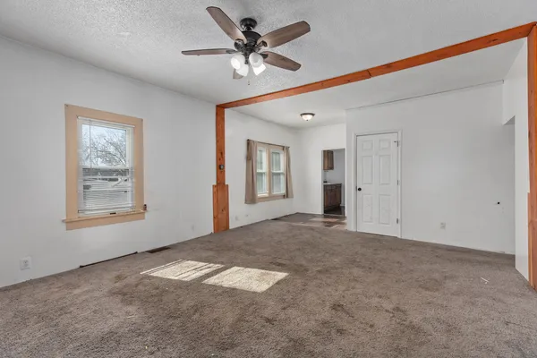 an empty room with windows and fan