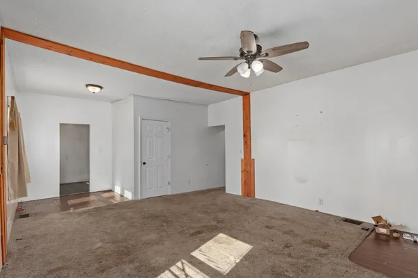 a view of a room with a ceiling fan and hardwood floor