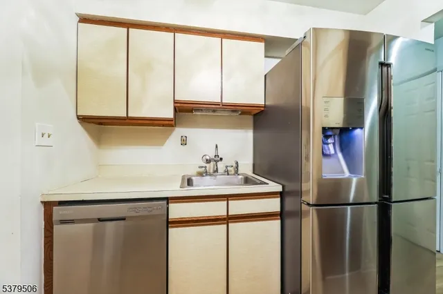 a kitchen with a sink a refrigerator and a window