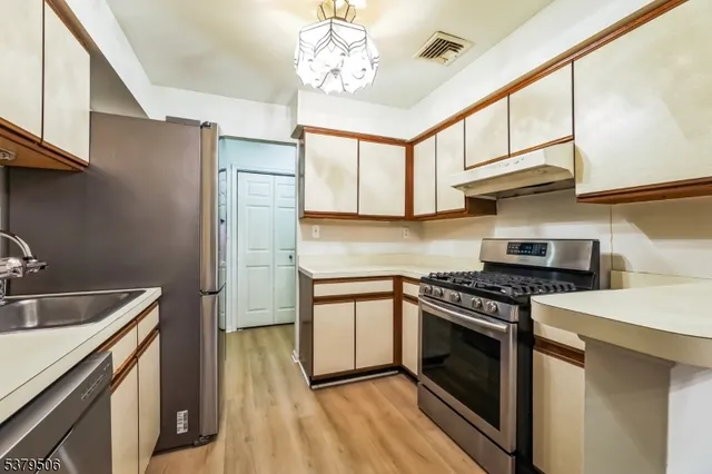 a kitchen with stainless steel appliances granite countertop a stove sink and cabinets