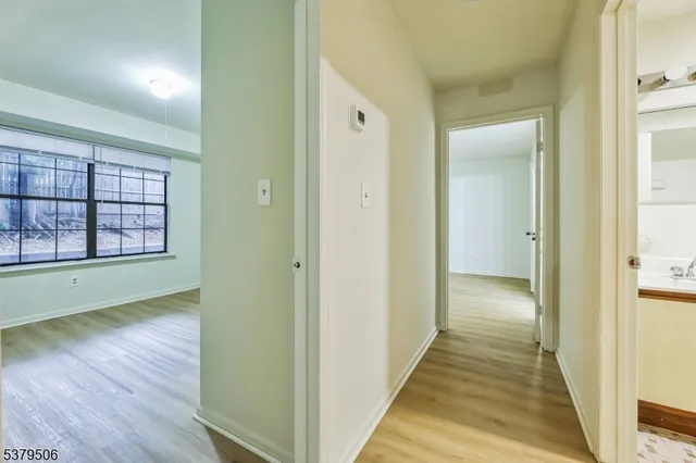 a view of a hallway with wooden floor and windows