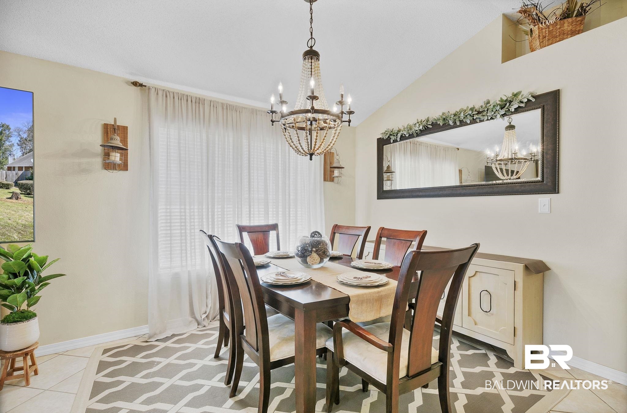 11103 Pontchartrain Loop Daphne, AL 36526 - Photo 14 of 29 Tiled dining space with baseboards, plenty of natural light, a notable chandelier, and vaulted ceiling