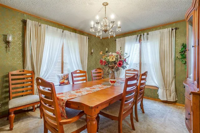 a view of a dining room with furniture and chandelier