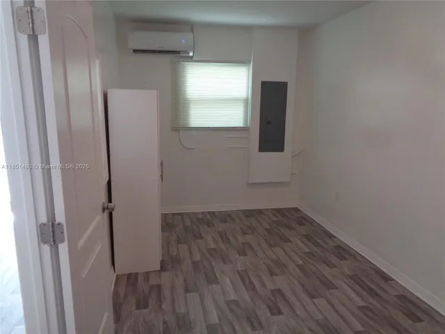 a view of a room with wooden floor and mirror