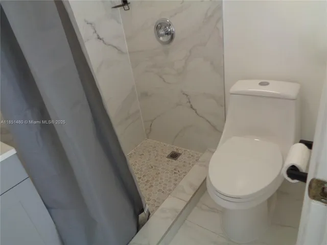 a bathroom with a toilet and a shower