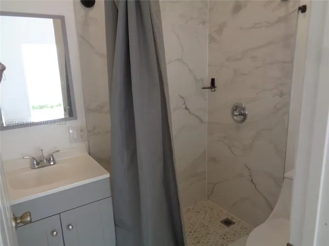 a bathroom with a shower and sink