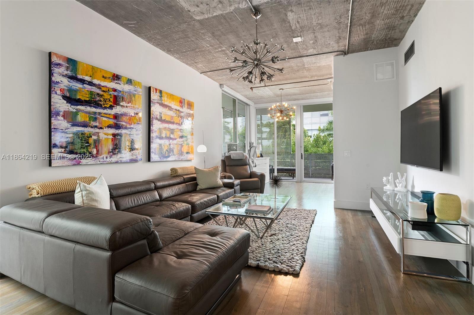 1700 Meridian Avenue, Unit 307 Miami Beach, FL 33139 - Photo 11 of 32 a living room with furniture a flat screen tv and a large window