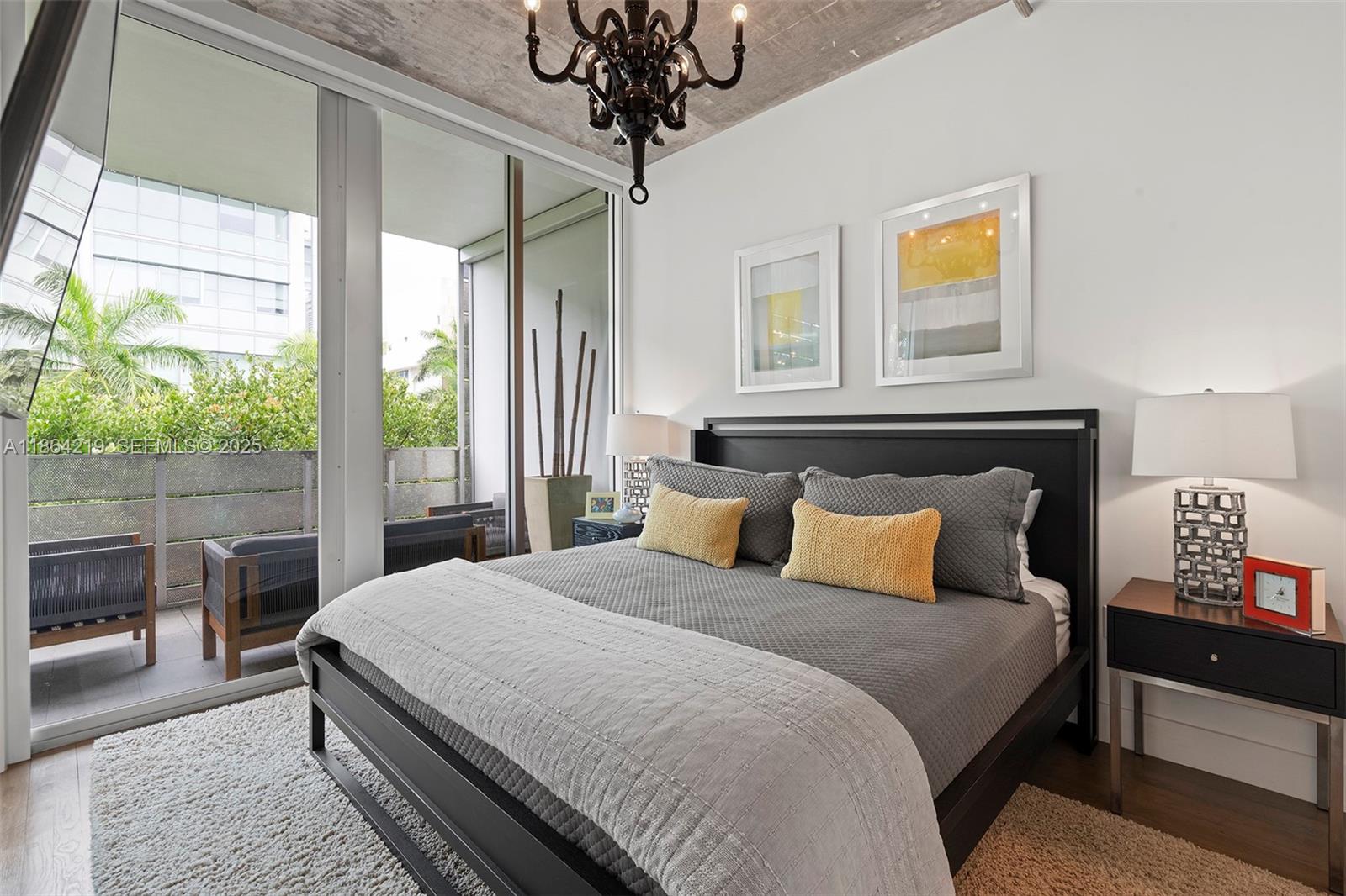 1700 Meridian Avenue, Unit 307 Miami Beach, FL 33139 - Photo 18 of 32 a bedroom with a bed and a chandelier