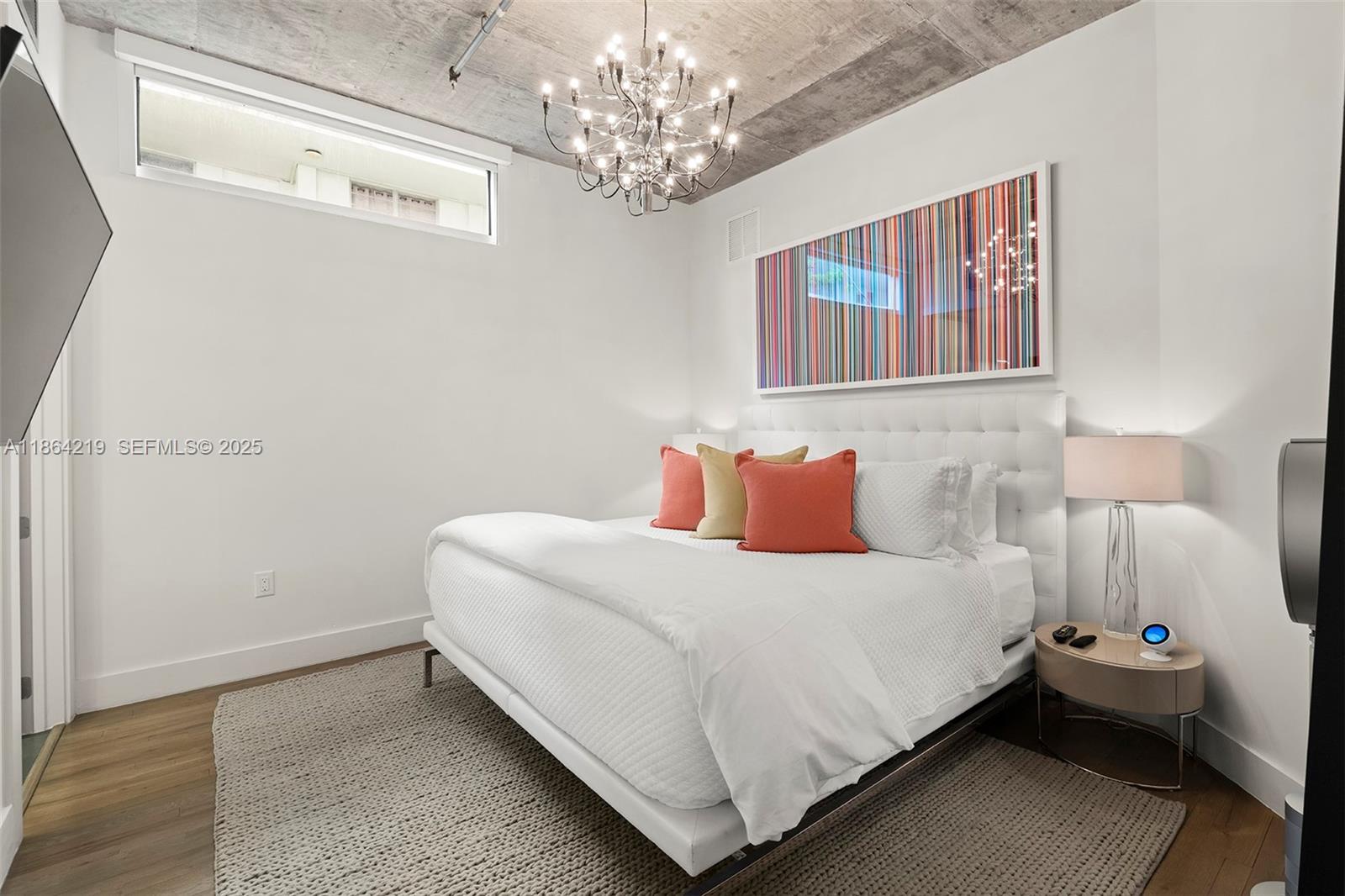 1700 Meridian Avenue, Unit 307 Miami Beach, FL 33139 - Photo 22 of 32 a bedroom with a bed and a chandelier