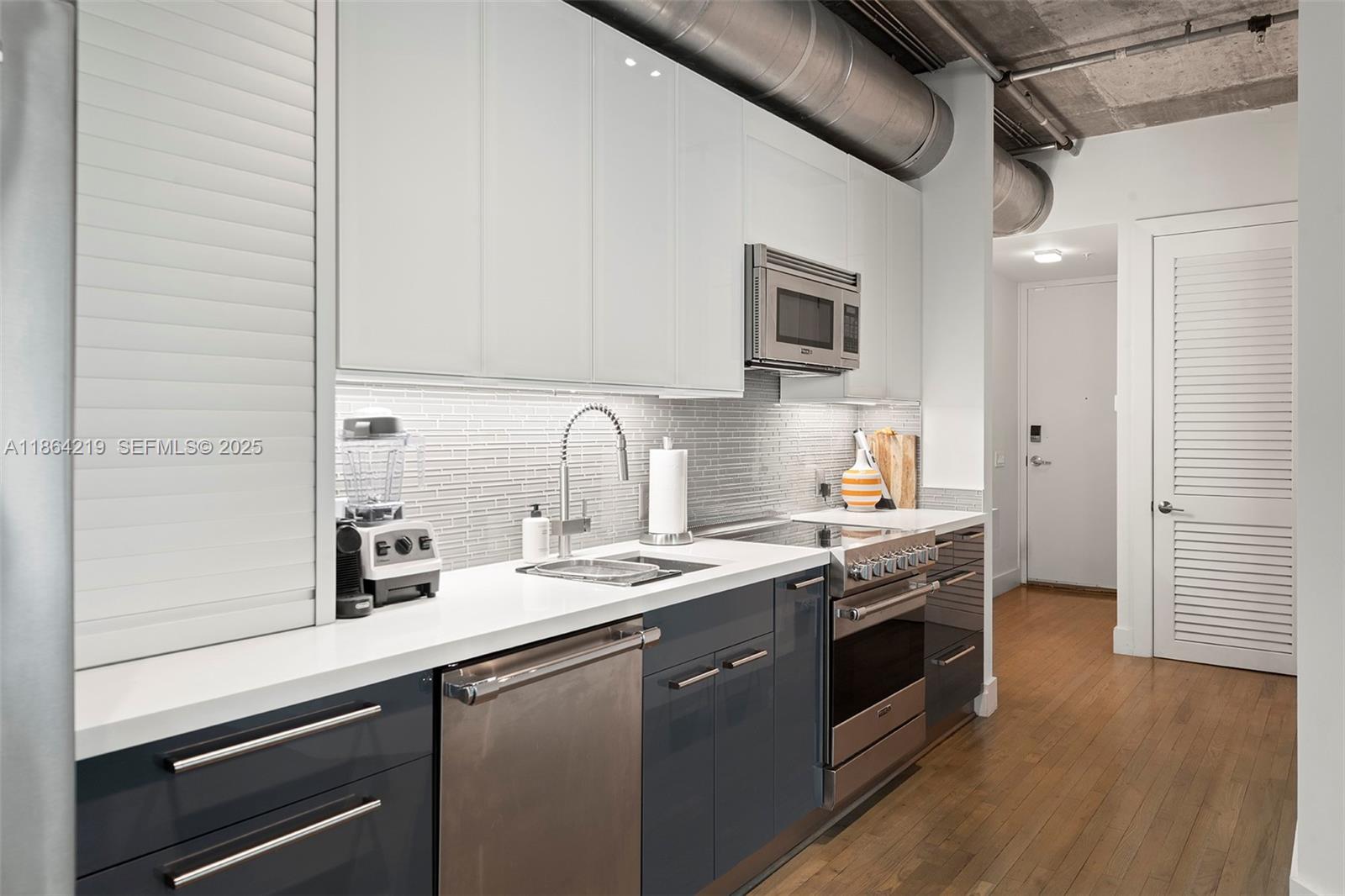 1700 Meridian Avenue, Unit 307 Miami Beach, FL 33139 - Photo 7 of 32 a kitchen with stainless steel appliances granite countertop a sink a stove and a refrigerator