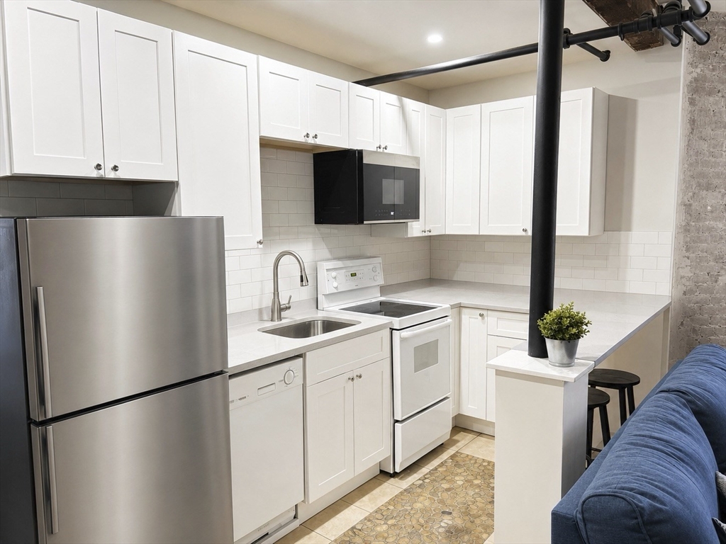 147 Winthrop Road, Unit 2 Brookline, MA 02445 - Photo 2 of 19 a kitchen with stainless steel appliances a refrigerator sink and white cabinets