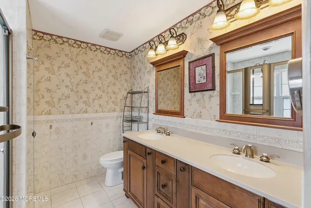 a bathroom with a double vanity sink toilet and shower